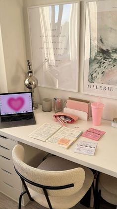 a white desk topped with a laptop computer sitting next to a pink heart shaped object