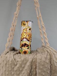 a handbag with a sunflower print on it and a straw hat hanging from the handle