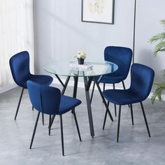 a glass table with four blue chairs around it and a potted plant in the corner