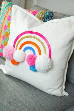 two pom - poms are on the back of a pillow that is sitting on a couch