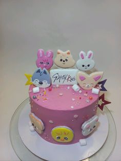 a pink birthday cake decorated with animals and stars