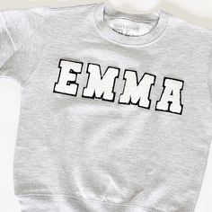 Our Custom mini chenille patch sweatshirt has so many options. It makes the perfect gift and is a great custom option Letters are available in both a white black option and a multi- color option for a fun youthful look. Sweatshirt runs true to size for men and kids. It's suggested women size down for a more fitted look. Women keep your traditional size for a relaxed/oversized fit. * Iron On Letter patches * Customizable Clothing * Personalized Name * Mini Letter Patches How to order: Step 1) Cho Chenille Patch Sweatshirt, Shirt Patches, Iron On Letter Patches, Sweatshirt Ideas, Patch Sweatshirt, Heather Grey Sweatshirt, Customizable Shirts, Chenille Patch, Sibling Shirts