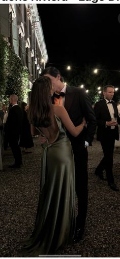 a man and woman kissing in front of a building at night with the caption's photo below it