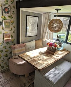 a dining room table and bench in front of a window with floral wallpaper on the walls