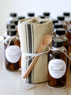 several bottles of honey sit next to each other on a table with a wooden spoon