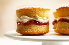 two mini cakes sitting on top of a white cake plate