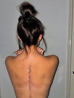 the back of a woman's body with writing on her lower back and neck