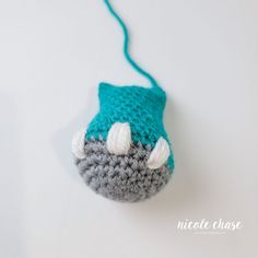 a crocheted blue and gray toy with white horns