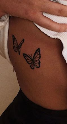 a woman's stomach with two butterflies on it and the bottom part of her belly