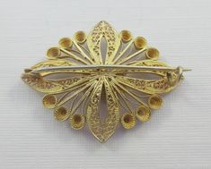 A beautiful gold over sterling silver filigree brooch depicting a flower set in a geometric pattern. Intricate design and very detailed. Some patina on it. C clasp. Please ask for additional pictures. Not marked, but tested as sterling silver. Some markings on the clasp and pin, but I can't identify them. Measurements: approx. 1.7 inches long and approx. 1.3 inches wide Please note that due to lighting effects, monitor's brightness, contrast and other settings, there might be some slight differe Leaf Scarf, Floral Geometric, Sterling Silver Filigree, Silver Filigree, Intricate Design, A Flower, Brooch Pin, Brooches, Patina