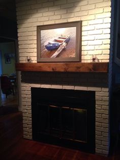 a white brick fireplace with a painting on the mantle