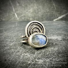 This solid sterling silver ring features a colorful and faceted natural Moonstone gem set into a unique geometric design.  Check out the coordinating pendant in the shop while it's still there! Weight: 8.9 grams   This ring is currently a size 7 but can be sized to a 7.5 US. Delivered  in a Silver Fig gift box with accompanying Healing Properties Card and a Sunshine Cloth (to polish later). Moonstone Healing properties: A stone of new beginnings that helps one connect with the Divine Feminine. Improves emotional regulation and is beneficial for PMS, pregnancy, and childbirth. Helps one to become more attuned with their feelings and emotions. Modern Handmade Sterling Silver Moonstone Ring, Handmade Modern Moonstone Ring In Sterling Silver, Moonstone Healing Properties, The Divine Feminine, Moonstone Ring Sterling Silver, Emotional Regulation, The Divine, Divine Feminine, Healing Properties