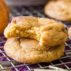 two cookies stacked on top of each other on a cooling rack next to an orange