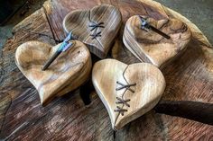 three wooden hearts with laces on them are sitting on a piece of wood that has been cut in half