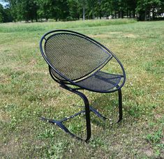 an empty chair sitting in the middle of a field