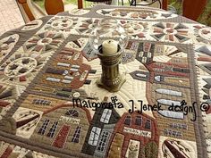 a table with a quilted table cloth on it and a candle in the center