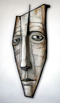 a face made out of wood on a white wall