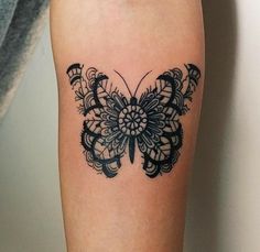 a black and white butterfly tattoo on the right leg, it looks like an intricate design