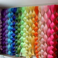 many different colors of bows are lined up on the wall in front of each other