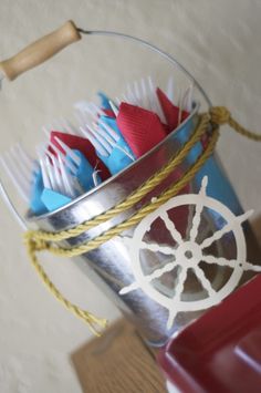 a bucket filled with toothbrushes sitting on top of a wooden table