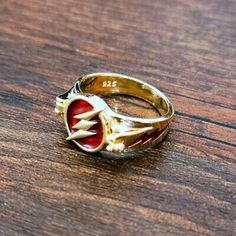 a close up of a ring on a wooden table with a red and white design