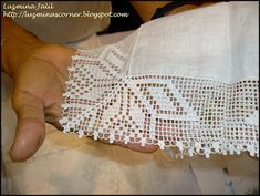 a person is holding an object with white lace on it's arm and hand