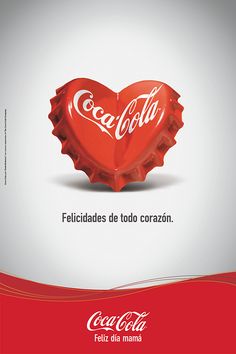 a red heart shaped bottle cap with the word coca - cola written in spanish on it