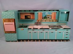 a doll house kitchen with blue cabinets and white counter tops, including a stove top oven