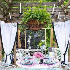 an outdoor dining area with chairs, table and potted plants