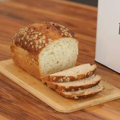 a loaf of bread sitting on top of a wooden cutting board next to a box