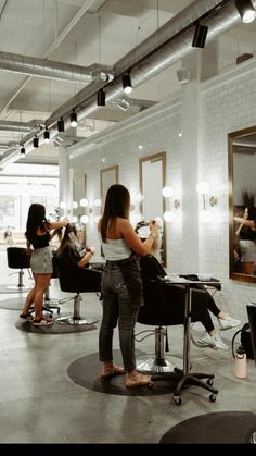 a woman is getting her hair done in a beauty salon while others are taking pictures