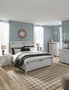 a bedroom with blue walls and white furniture