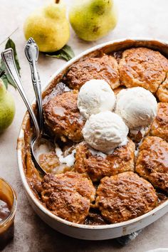 an apple cobbler with ice cream and caramel syrup on the side next to apples