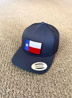 "This is a NEW Texas Flag embroidered patch applied by hand to a high quality Yupoong or Richardson brand SnapBack Trucker style hat Yupoong Classic SnapBacks are 65% Polyester/35% Cotton Structured mid-profile six-panel Permacurv Visor adjustable 6 7/8\" to 7 1/2\" Richardson Hats are 60% cotton/40% polyester Structured mid-profile six-panel Pre-curved Visor adjustable snapback closure 6 3/4\" -7 5/8\" Every Hat Design we offer is Created and Individually HANDCRAFTED to order in the USA! *Due t Navy Curved Bill Hat With Logo Patch, Trucker Hat With Embroidered Patch Curved Brim, Navy Flat Brim Hat With Logo Patch, Embroidered Snapback Hat, One Size Fits Most, Embroidered Patch Snapback Hat, Blue Snapback Trucker Hat With Embroidered Patch, Blue Embroidered Snapback Trucker Hat, Embroidered Patch Snapback Hat With Curved Brim, Adjustable Hat With Patches And Curved Bill