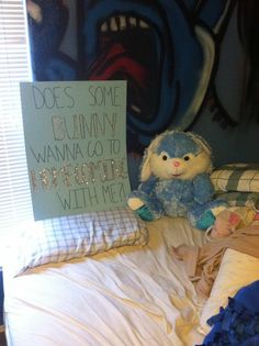 a stuffed animal sitting on top of a bed next to a sign that says does some bunny wannas to pretend with me