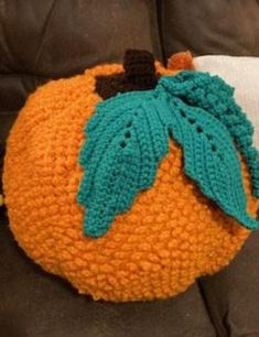 a crocheted pumpkin sitting on top of a couch