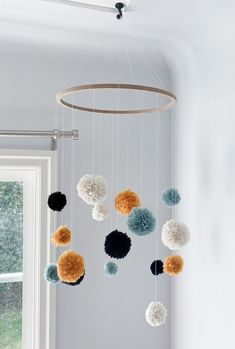 a mobile with pom - poms hanging from the ceiling