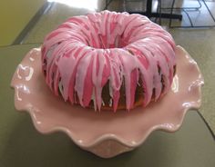 a donut with pink icing sitting on a plate