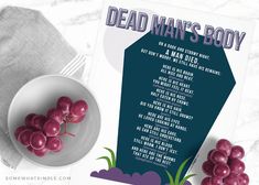 there is a bowl of grapes next to a dead man's body poster on the table