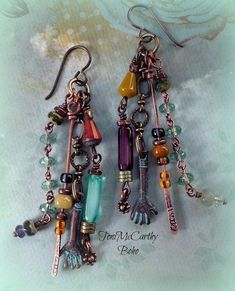 two pairs of earrings with charms hanging from them