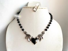 **PLEASE PLACE HOLIDAY ORDERS BEFORE DEC 14 7PM EST!! SHOP BREAK: ORDERS MADE AFTER DEC 15 WILL NOT BE DISPATCHED UNTIL JAN 2 ** THANK YOU ♥ gothic inspired black pearl choker with a winged black heart <3 adjustable chain and can be customized for various lengths.  each size will have a two inch extension to accommodate for different lengths or mismeasurements when measuring neck size the length of the pearls will not exceed 12-13 inches, the rest will be silver chain to accommodate larger sizes Black Alternative Style Choker Necklace, Black Heart-shaped Metal Choker, Black Grunge Necklace For Gift, Black Heart-shaped Emo Choker, Black Emo Choker Necklace, Emo Black Choker Necklace, Leather Heart Choker, Grunge Chokers, Edgy Y2k