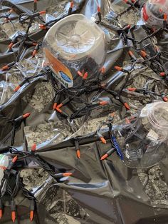 many wires are wrapped in plastic bags on the floor with orange and black pins sticking out of them