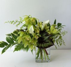 a vase filled with green and white flowers