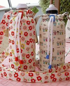 two water bottles sitting next to each other on top of a pink cloth covered table