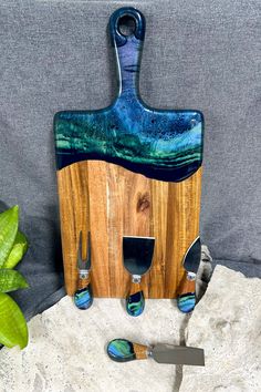 a wooden cutting board sitting on top of a table next to knifes and knives