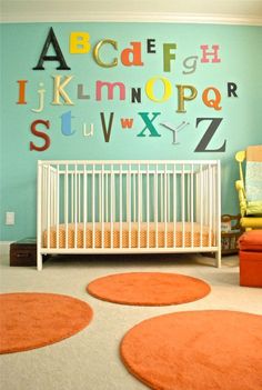 a baby's room with an orange rug and white crib in front of the wall