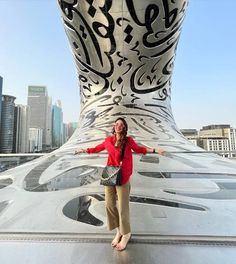 a woman standing in front of a large metal structure