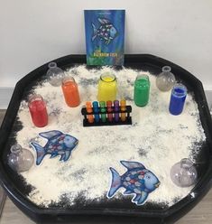 a black tray filled with lots of different types of paint and crayons on top of it