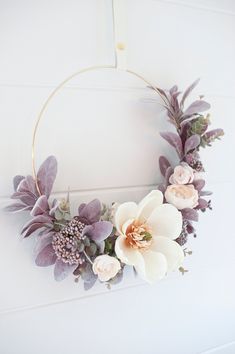 a wreath with flowers hanging on the wall