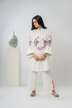 Intricate embroidery, buttoned down shirt and cropped lose pants. Perfect blend of comfort and style for any occasion.  -Premium Irish Cotton  -Buttoned down oversize shirt with cropped lose pants -Oversize dropped shoulder embroidered sleeves  -Hand-Machine Embroidered  -cropped lose pants with embroidery  -Adjustable pant with elastic at back for comfort  -Hanging loop for your ease -Hand wash only Spring Workwear Long Sleeve Palazzo Set, Festive Floral Embroidered Sets For Workwear, Traditional Spring Workwear Sets, Floral Embroidery Long Sleeve Sets For Workwear, Traditional Embroidered Workwear Sets, Festive Embroidered Workwear Sets, Spring Embroidered Pant Set For Workwear, Traditional White Sets For Workwear, Embroidered Cotton Palazzo Set With Straight Pants